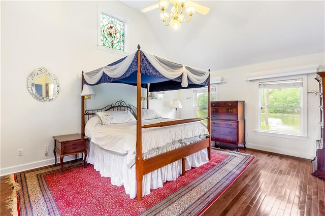 bedroom with baseboards, vaulted ceiling, and wood finished floors