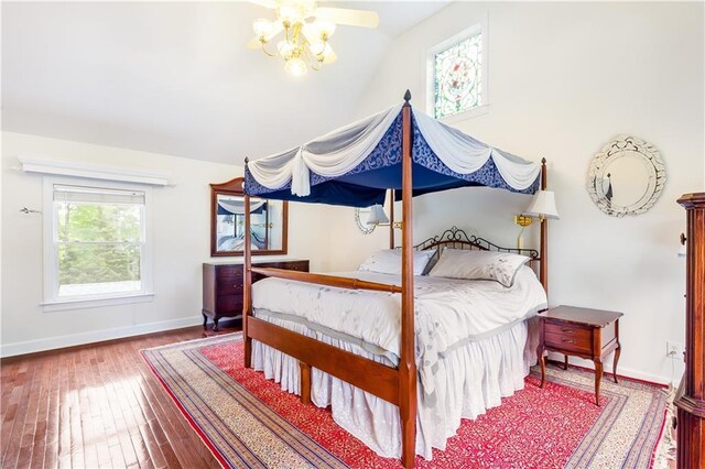 bedroom with wood-type flooring, baseboards, and lofted ceiling