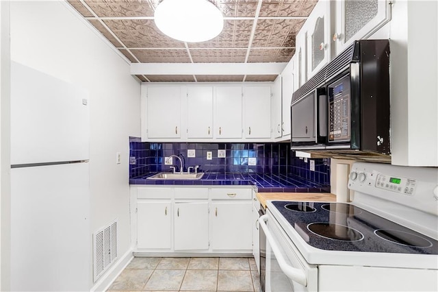 kitchen with visible vents, white appliances, an ornate ceiling, white cabinets, and a sink