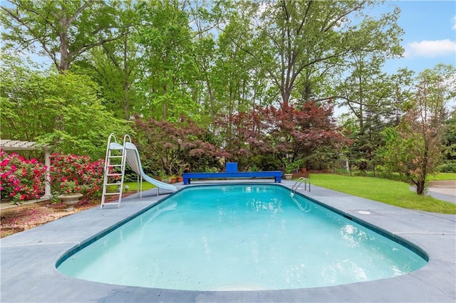 view of swimming pool featuring a water slide, a yard, and a covered pool