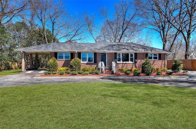 single story home featuring a front lawn, aphalt driveway, a carport, fence, and brick siding