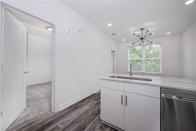 kitchen featuring stainless steel dishwasher, dark wood-type flooring, sink, an inviting chandelier, and white cabinetry