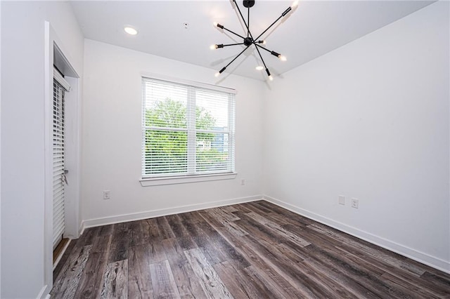 unfurnished room featuring dark hardwood / wood-style floors and a notable chandelier