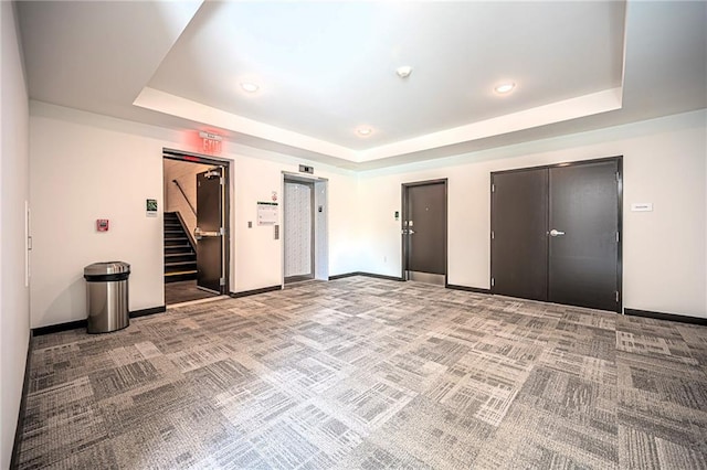 interior space featuring carpet floors and a tray ceiling