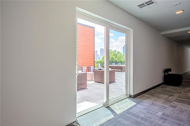 doorway to outside featuring dark carpet