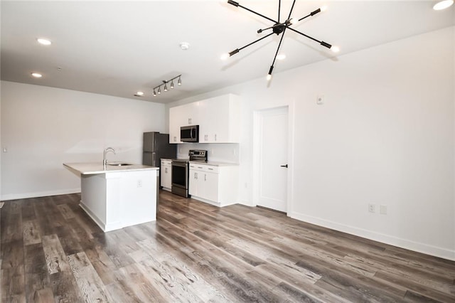 kitchen with a kitchen island with sink, sink, dark wood-type flooring, and appliances with stainless steel finishes