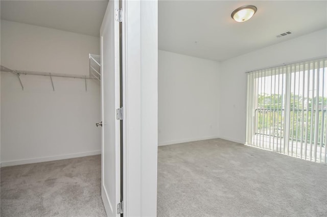 walk in closet featuring light colored carpet