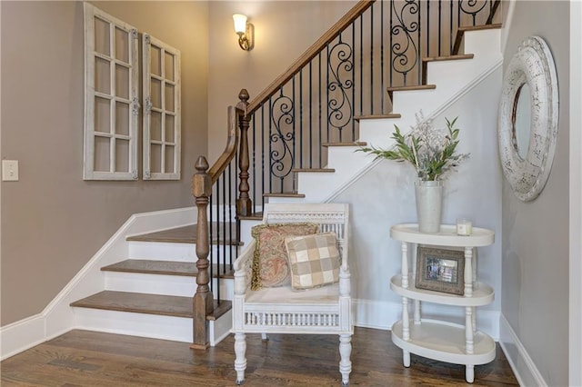 stairway with wood finished floors and baseboards