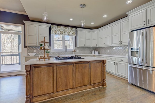 kitchen with gas stovetop, white cabinetry, light countertops, and stainless steel fridge with ice dispenser