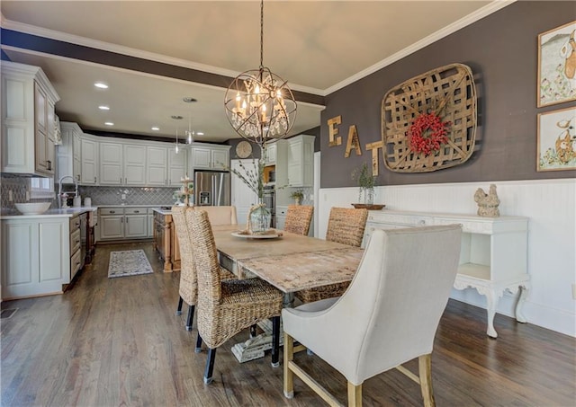 dining room with a chandelier, recessed lighting, a wainscoted wall, dark wood-style flooring, and ornamental molding