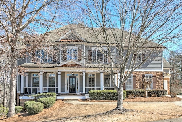 view of front facade with a porch, french doors, and stone siding