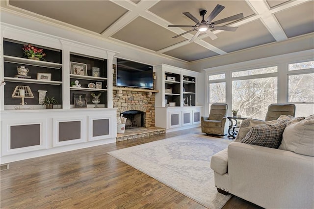 living room featuring visible vents, a ceiling fan, a stone fireplace, wood finished floors, and coffered ceiling