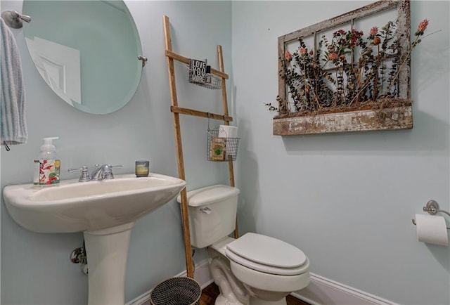 half bathroom with toilet and baseboards