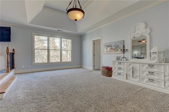 unfurnished bedroom with baseboards, visible vents, ornamental molding, a tray ceiling, and carpet flooring