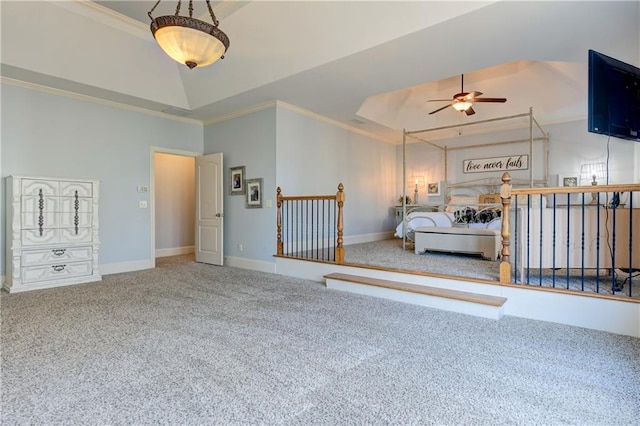 carpeted bedroom featuring baseboards, a raised ceiling, and crown molding