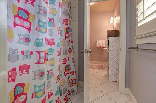 bathroom featuring curtained shower, tile patterned flooring, and baseboards