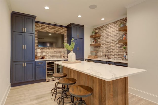 bar featuring recessed lighting, beverage cooler, light wood-style floors, backsplash, and wet bar