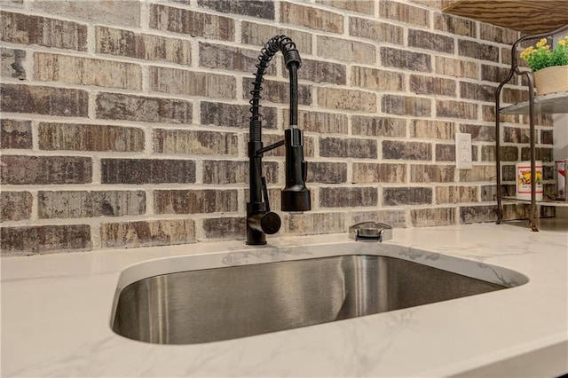 room details with light stone counters and a sink