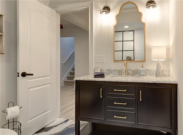 bathroom with wood finished floors, vanity, and crown molding