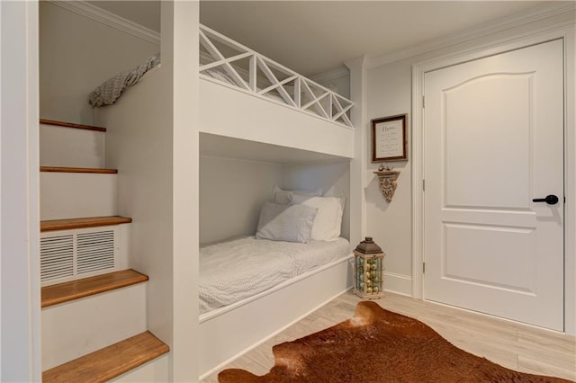 unfurnished bedroom featuring baseboards, ornamental molding, and wood finished floors