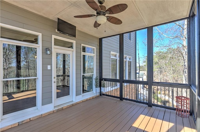 unfurnished sunroom featuring ceiling fan