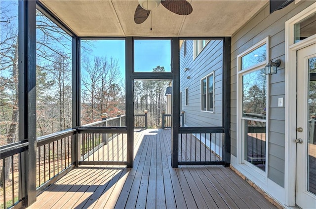 unfurnished sunroom featuring ceiling fan