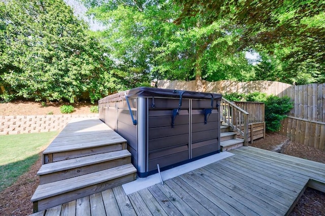 deck featuring a fenced backyard and a hot tub