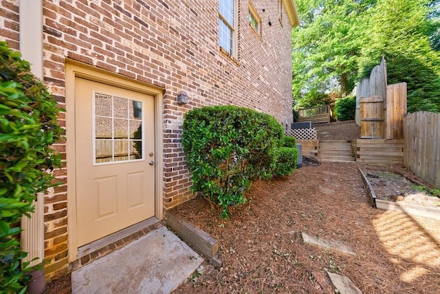 entrance to property with fence and brick siding