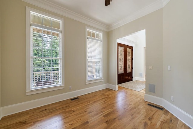 entryway with baseboards, ornamental molding, wood finished floors, and visible vents