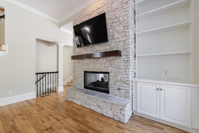 unfurnished living room with a stone fireplace, crown molding, baseboards, and light wood-style flooring