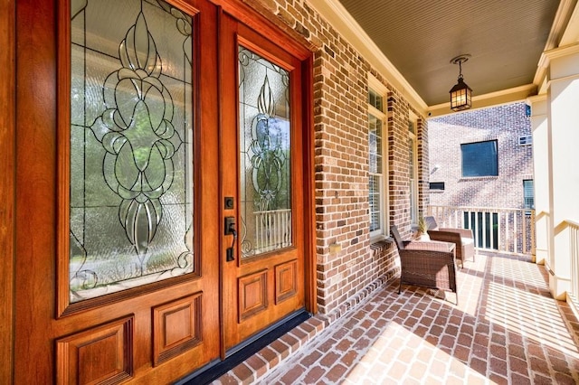 property entrance featuring brick siding and a porch