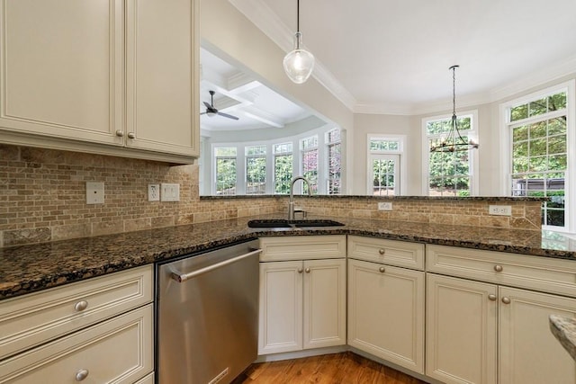 kitchen with dark stone countertops, stainless steel dishwasher, ornamental molding, and a sink