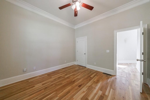 empty room featuring light wood-style flooring, visible vents, baseboards, ceiling fan, and ornamental molding