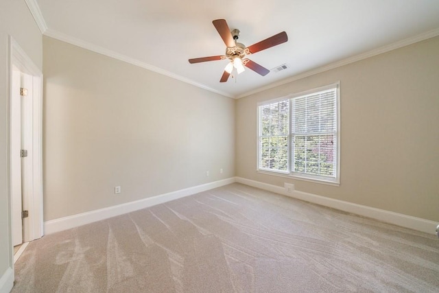 carpeted empty room featuring baseboards, a ceiling fan, visible vents, and crown molding