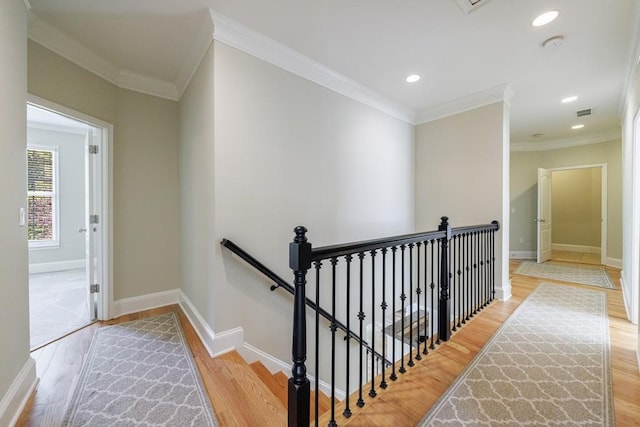 hallway with wood finished floors, baseboards, and an upstairs landing