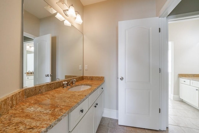 bathroom with baseboards, tile patterned flooring, and vanity