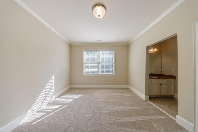 spare room with crown molding, a sink, light colored carpet, baseboards, and visible vents