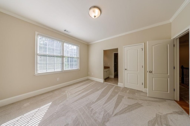 unfurnished bedroom featuring baseboards, visible vents, light colored carpet, and crown molding
