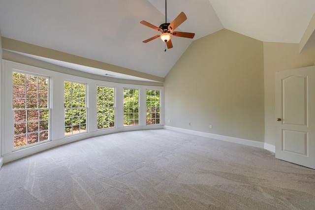 carpeted spare room with high vaulted ceiling, baseboards, a ceiling fan, and a healthy amount of sunlight