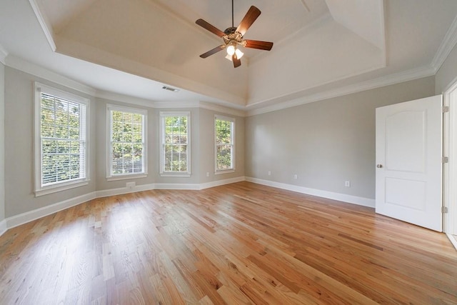spare room with a ceiling fan, baseboards, a raised ceiling, and light wood-style flooring