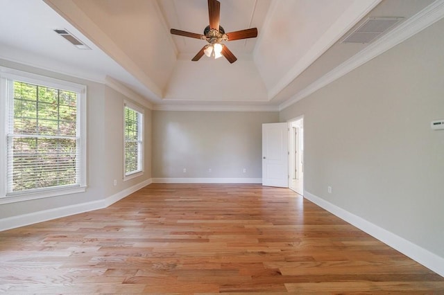 spare room with baseboards, a ceiling fan, light wood finished floors, and visible vents