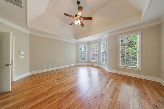 spare room featuring a tray ceiling, visible vents, and light wood-style floors