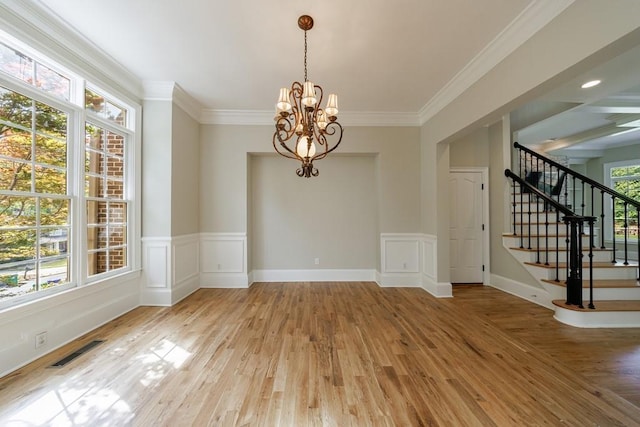 unfurnished dining area with visible vents, ornamental molding, a chandelier, light wood-style flooring, and stairs