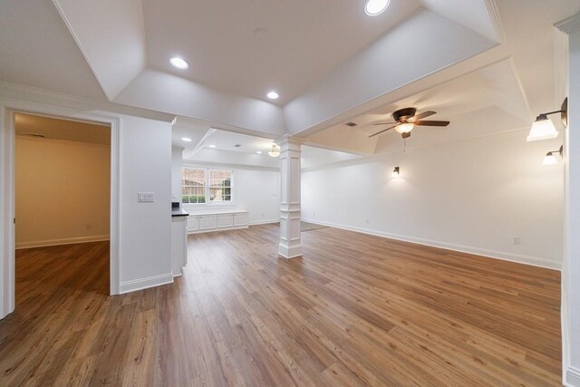 unfurnished living room with recessed lighting, ornate columns, a ceiling fan, wood finished floors, and a raised ceiling