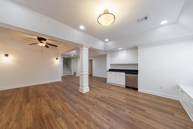 interior space with dishwasher, visible vents, wood finished floors, baseboards, and white cabinetry