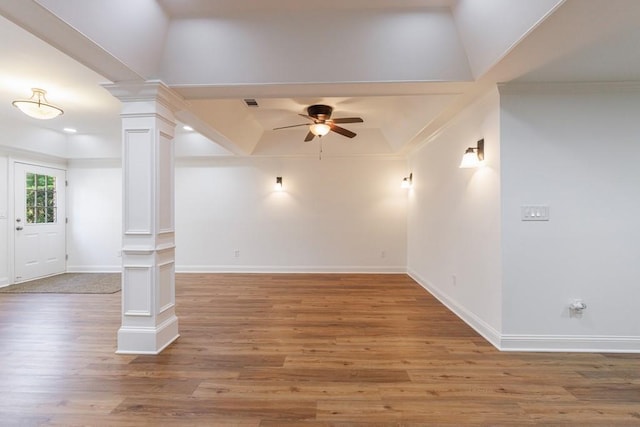 unfurnished living room with wood finished floors, baseboards, ceiling fan, and decorative columns