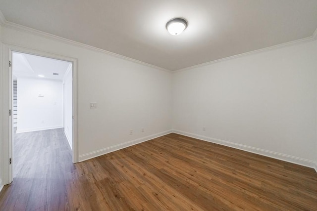 empty room with baseboards, ornamental molding, and dark wood finished floors