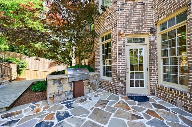 view of patio / terrace with fence, exterior kitchen, and area for grilling