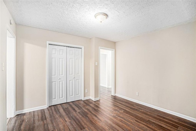 unfurnished bedroom with a textured ceiling, a closet, and dark hardwood / wood-style flooring