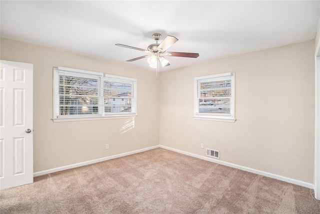 carpeted spare room with ceiling fan and a wealth of natural light